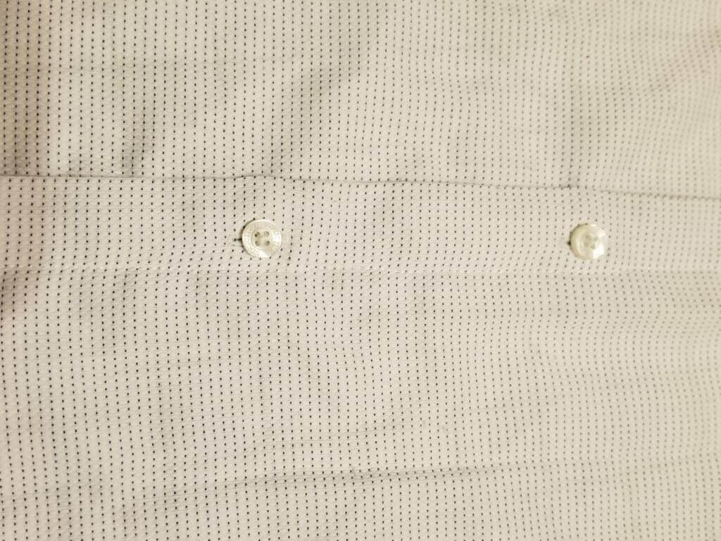 sewing up the buttons on the men's shirt