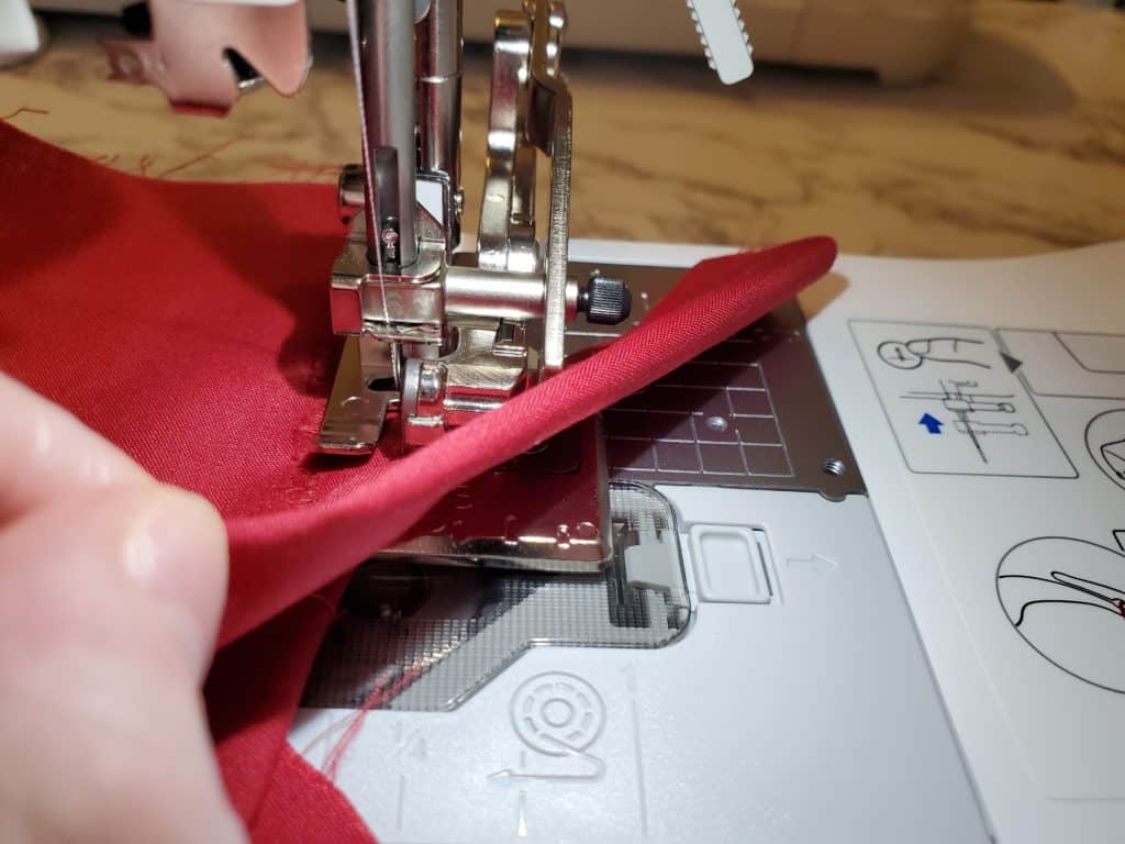 place the fabric over the overlocker foot