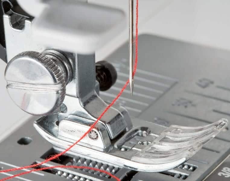 Thread sewing machine needle from front to back through eye