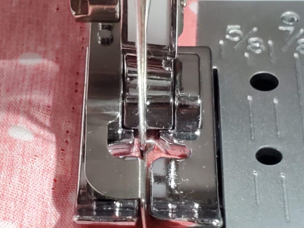 zoomed in version of blind hem foot and sewing machine stitching