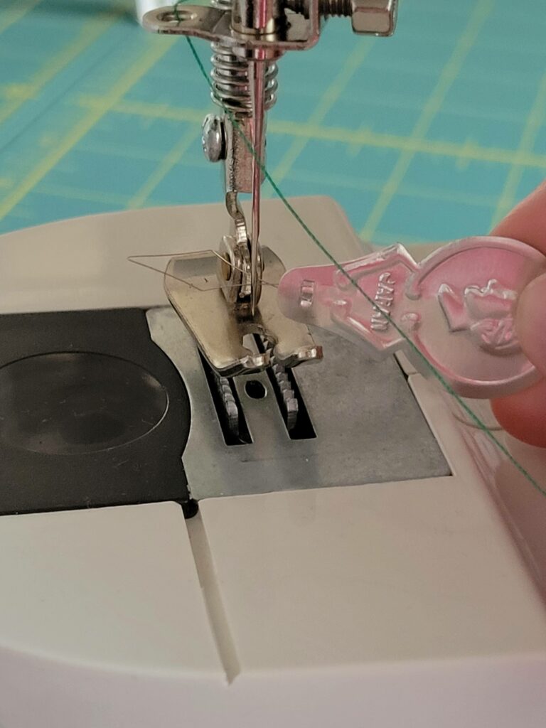 insert wire needle threader through eye of needle